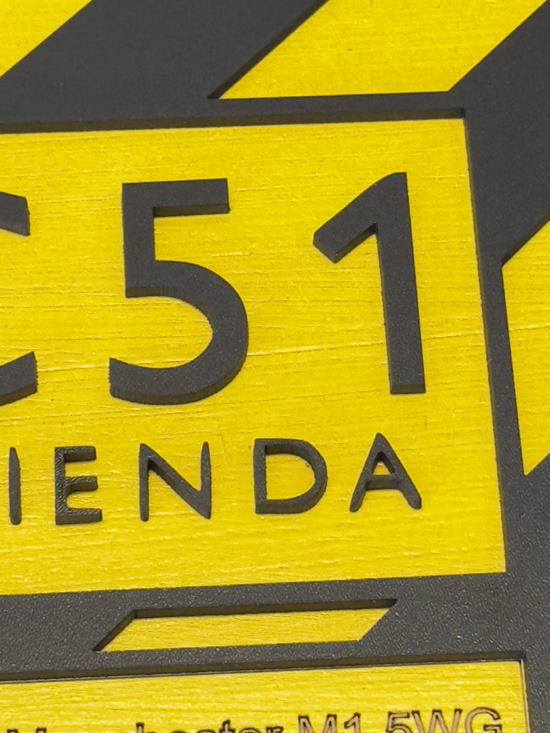 Close‑up of FAC51 typography on layered MDF plaque